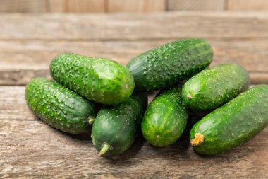 Ahşap arka planda salatalık. Arka planda bir parça salatalık. Taze organik yeşil salatalık turşusu. Vejetaryen. Salata malzemesi. Çiftlik sebzeleri. Sebzeleri bıçakla kes. Mesaj için yer var. Boşluğu kopyala