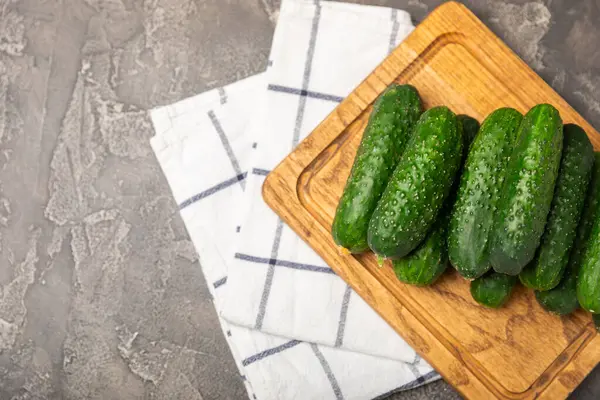 Ahşap arka planda salatalık. Arka planda bir parça salatalık. Taze organik yeşil salatalık turşusu. Vejetaryen. Salata malzemesi. Çiftlik sebzeleri. Sebzeleri bıçakla kes. Mesaj için yer var. Boşluğu kopyala