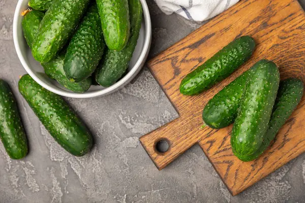 Ahşap arka planda salatalık. Arka planda bir parça salatalık. Taze organik yeşil salatalık turşusu. Vejetaryen. Salata malzemesi. Çiftlik sebzeleri. Sebzeleri bıçakla kes. Mesaj için yer var. Boşluğu kopyala