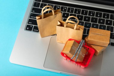 Çevrimiçi alışveriş kavramı. Karton kutu ve parlak renkli bir arka planda tramvayda alışveriş poşetleri. Alışveriş sepeti. İnternetten bilgisayar, tablet, telefon ve kredi kartı kullanarak alışveriş. Eve teslim.