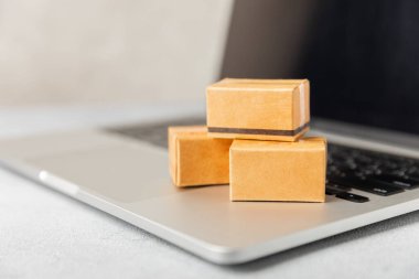 Çevrimiçi alışveriş kavramı. Karton kutu ve parlak renkli bir arka planda tramvayda alışveriş poşetleri. Alışveriş sepeti. İnternetten bilgisayar, tablet, telefon ve kredi kartı kullanarak alışveriş. Eve teslim.