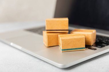 Çevrimiçi alışveriş kavramı. Karton kutu ve parlak renkli bir arka planda tramvayda alışveriş poşetleri. Alışveriş sepeti. İnternetten bilgisayar, tablet, telefon ve kredi kartı kullanarak alışveriş. Eve teslim.