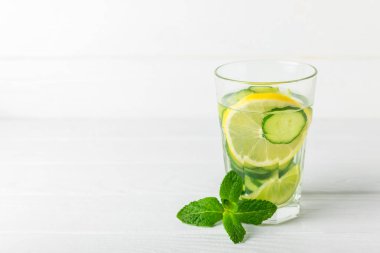 Salatalık suyu, limon, nane ve ahşap bir masada. İçme bardağında dilimlenmiş salatalık ile karıştırılmış su. Tonik ferahlatıcı bir içecek. Salatalık limonata. Doğal soğutma içeceği. Boşluğu kopyala.