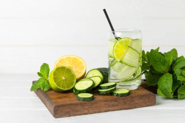 Salatalık suyu, limon, nane ve ahşap bir masada. İçme bardağında dilimlenmiş salatalık ile karıştırılmış su. Tonik ferahlatıcı bir içecek. Salatalık limonata. Doğal soğutma içeceği. Boşluğu kopyala.