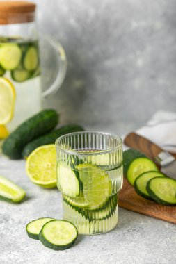Salatalık suyu, limon, nane ve ahşap bir masada. İçme bardağında dilimlenmiş salatalık ile karıştırılmış su. Tonik ferahlatıcı bir içecek. Salatalık limonata. Doğal soğutma içeceği. Boşluğu kopyala.