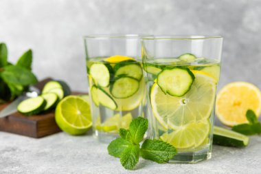 Salatalık suyu, limon, nane ve ahşap bir masada. İçme bardağında dilimlenmiş salatalık ile karıştırılmış su. Tonik ferahlatıcı bir içecek. Salatalık limonata. Doğal soğutma içeceği. Boşluğu kopyala.