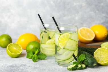 Salatalık suyu, limon, nane ve ahşap bir masada. İçme bardağında dilimlenmiş salatalık ile karıştırılmış su. Tonik ferahlatıcı bir içecek. Salatalık limonata. Doğal soğutma içeceği. Boşluğu kopyala.