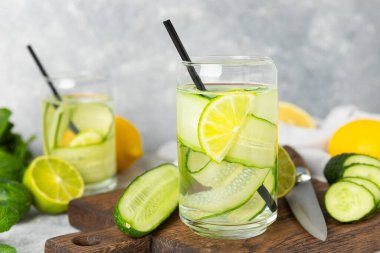 Salatalık suyu, limon, nane ve ahşap bir masada. İçme bardağında dilimlenmiş salatalık ile karıştırılmış su. Tonik ferahlatıcı bir içecek. Salatalık limonata. Doğal soğutma içeceği. Boşluğu kopyala.