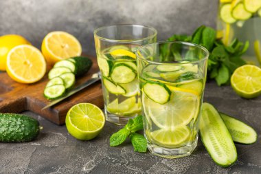 Salatalık suyu, limon, nane ve ahşap bir masada. İçme bardağında dilimlenmiş salatalık ile karıştırılmış su. Tonik ferahlatıcı bir içecek. Salatalık limonata. Doğal soğutma içeceği. Boşluğu kopyala.