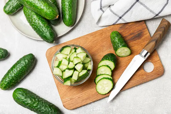 Ahşap arka planda salatalık. Arka planda bir parça salatalık. Taze organik yeşil salatalık turşusu. Vejetaryen. Salata malzemesi. Çiftlik sebzeleri. Sebzeleri bıçakla kes. Mesaj için yer var. Boşluğu kopyala