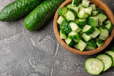 Ahşap arka planda salatalık. Arka planda bir parça salatalık. Taze organik yeşil salatalık turşusu. Vejetaryen. Salata malzemesi. Çiftlik sebzeleri. Sebzeleri bıçakla kes. Mesaj için yer var. Boşluğu kopyala