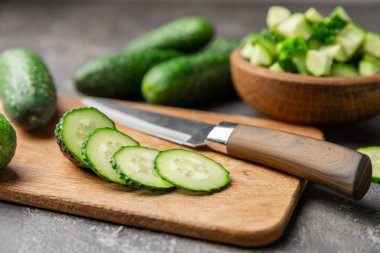 Ahşap arka planda salatalık. Arka planda bir parça salatalık. Taze organik yeşil salatalık turşusu. Vejetaryen. Salata malzemesi. Çiftlik sebzeleri. Sebzeleri bıçakla kes. Mesaj için yer var. Boşluğu kopyala