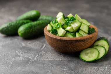Ahşap arka planda salatalık. Arka planda bir parça salatalık. Taze organik yeşil salatalık turşusu. Vejetaryen. Salata malzemesi. Çiftlik sebzeleri. Sebzeleri bıçakla kes. Mesaj için yer var. Boşluğu kopyala