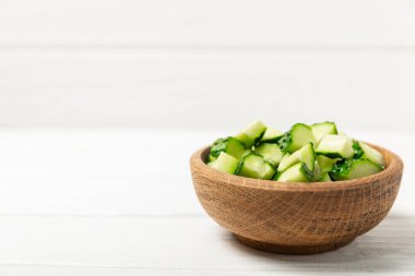 Ahşap arka planda salatalık. Arka planda bir parça salatalık. Taze organik yeşil salatalık turşusu. Vejetaryen. Salata malzemesi. Çiftlik sebzeleri. Sebzeleri bıçakla kes. Mesaj için yer var. Boşluğu kopyala