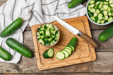 Ahşap arka planda salatalık. Arka planda bir parça salatalık. Taze organik yeşil salatalık turşusu. Vejetaryen. Salata malzemesi. Çiftlik sebzeleri. Sebzeleri bıçakla kes. Mesaj için yer var. Boşluğu kopyala