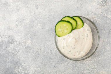 Ahşap bir masada salatalık kremalı tzatziki sosu. Tatar sosu. Geleneksel lezzetli aperatif. Yoğurt sosu. Tzatziki, salatalık, sarımsak, dereotu, limon, nane. Salata sosu. Kopya alanı.