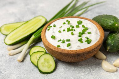 Ahşap bir masada salatalık kremalı tzatziki sosu. Tatar sosu. Geleneksel lezzetli aperatif. Yoğurt sosu. Tzatziki, salatalık, sarımsak, dereotu, limon, nane. Salata sosu. Kopya alanı.
