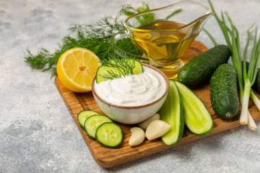 Ahşap bir masada salatalık kremalı tzatziki sosu. Tatar sosu. Geleneksel lezzetli aperatif. Yoğurt sosu. Tzatziki, salatalık, sarımsak, dereotu, limon, nane. Salata sosu. Kopya alanı.