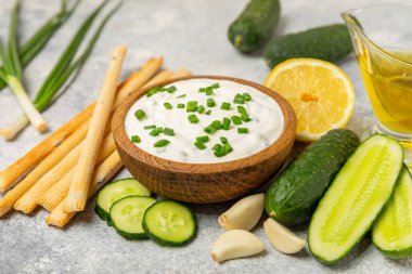 Ahşap bir masada salatalık kremalı tzatziki sosu. Tatar sosu. Geleneksel lezzetli aperatif. Yoğurt sosu. Tzatziki, salatalık, sarımsak, dereotu, limon, nane. Salata sosu. Kopya alanı.