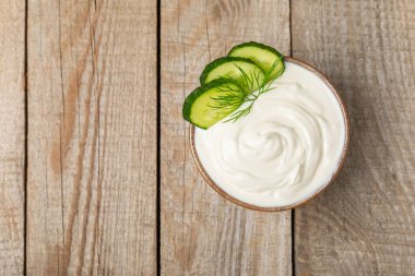 Ahşap bir masada salatalık kremalı tzatziki sosu. Tatar sosu. Geleneksel lezzetli aperatif. Yoğurt sosu. Tzatziki, salatalık, sarımsak, dereotu, limon, nane. Salata sosu. Kopya alanı.