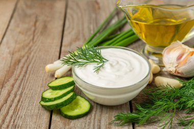 Ahşap bir masada salatalık kremalı tzatziki sosu. Tatar sosu. Geleneksel lezzetli aperatif. Yoğurt sosu. Tzatziki, salatalık, sarımsak, dereotu, limon, nane. Salata sosu. Kopya alanı.