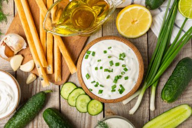 Ahşap bir masada salatalık kremalı tzatziki sosu. Tatar sosu. Geleneksel lezzetli aperatif. Yoğurt sosu. Tzatziki, salatalık, sarımsak, dereotu, limon, nane. Salata sosu. Kopya alanı.