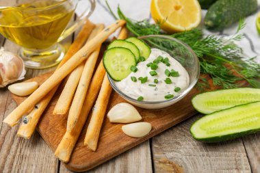 Ahşap bir masada salatalık kremalı tzatziki sosu. Tatar sosu. Geleneksel lezzetli aperatif. Yoğurt sosu. Tzatziki, salatalık, sarımsak, dereotu, limon, nane. Salata sosu. Kopya alanı.