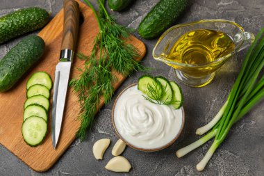 Ahşap bir masada salatalık kremalı tzatziki sosu. Tatar sosu. Geleneksel lezzetli aperatif. Yoğurt sosu. Tzatziki, salatalık, sarımsak, dereotu, limon, nane. Salata sosu. Kopya alanı.