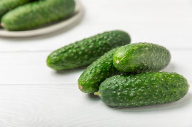 Ahşap arka planda salatalık. Arka planda bir parça salatalık. Taze organik yeşil salatalık turşusu. Vejetaryen. Salata malzemesi. Çiftlik sebzeleri. Sebzeleri bıçakla kes. Mesaj için yer var. Boşluğu kopyala