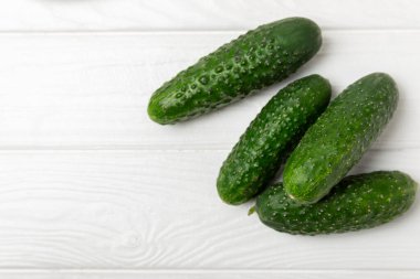 Ahşap arka planda salatalık. Arka planda bir parça salatalık. Taze organik yeşil salatalık turşusu. Vejetaryen. Salata malzemesi. Çiftlik sebzeleri. Sebzeleri bıçakla kes. Mesaj için yer var. Boşluğu kopyala