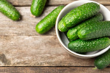 Ahşap arka planda salatalık. Arka planda bir parça salatalık. Taze organik yeşil salatalık turşusu. Vejetaryen. Salata malzemesi. Çiftlik sebzeleri. Sebzeleri bıçakla kes. Mesaj için yer var. Boşluğu kopyala