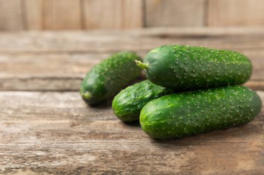 Ahşap arka planda salatalık. Arka planda bir parça salatalık. Taze organik yeşil salatalık turşusu. Vejetaryen. Salata malzemesi. Çiftlik sebzeleri. Sebzeleri bıçakla kes. Mesaj için yer var. Boşluğu kopyala