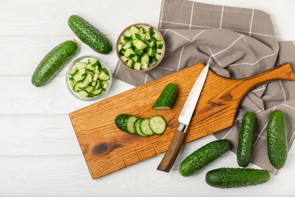 Ahşap arka planda salatalık. Arka planda bir parça salatalık. Taze organik yeşil salatalık turşusu. Vejetaryen. Salata malzemesi. Çiftlik sebzeleri. Sebzeleri bıçakla kes. Mesaj için yer var. Boşluğu kopyala