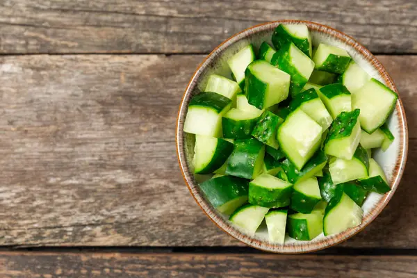 Ahşap arka planda salatalık. Arka planda bir parça salatalık. Taze organik yeşil salatalık turşusu. Vejetaryen. Salata malzemesi. Çiftlik sebzeleri. Sebzeleri bıçakla kes. Mesaj için yer var. Boşluğu kopyala