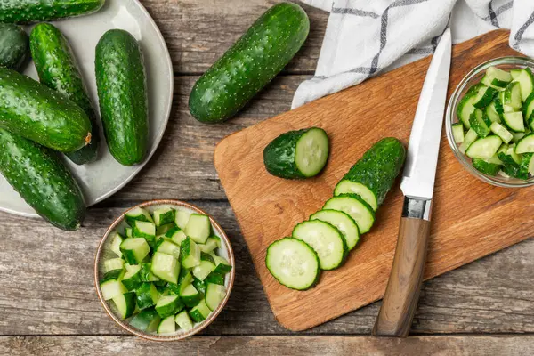 Ahşap arka planda salatalık. Arka planda bir parça salatalık. Taze organik yeşil salatalık turşusu. Vejetaryen. Salata malzemesi. Çiftlik sebzeleri. Sebzeleri bıçakla kes. Mesaj için yer var. Boşluğu kopyala