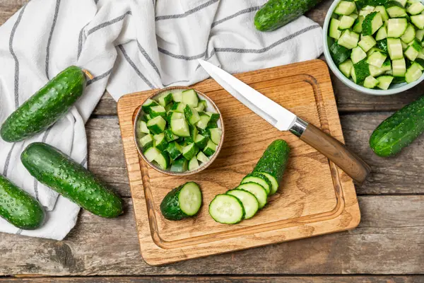 Ahşap arka planda salatalık. Arka planda bir parça salatalık. Taze organik yeşil salatalık turşusu. Vejetaryen. Salata malzemesi. Çiftlik sebzeleri. Sebzeleri bıçakla kes. Mesaj için yer var. Boşluğu kopyala