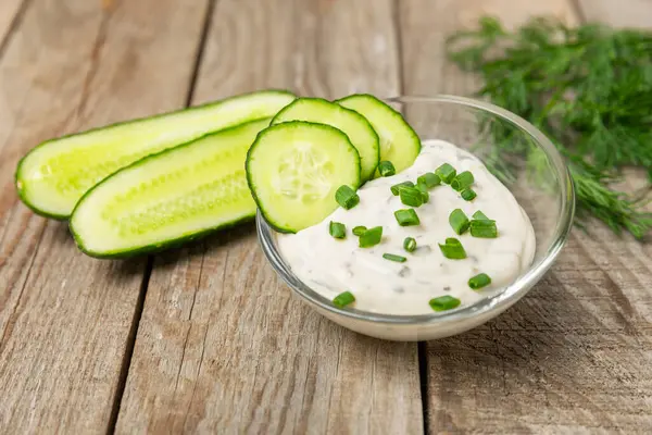 Ahşap bir masada salatalık kremalı tzatziki sosu. Tatar sosu. Geleneksel lezzetli aperatif. Yoğurt sosu. Tzatziki, salatalık, sarımsak, dereotu, limon, nane. Salata sosu. Kopya alanı.