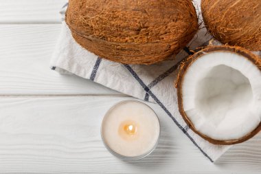 Tahta bir masada doğal hindistan cevizi mumları. Ev yapımı hindistan cevizi mumları ve aromatik yağ. Masaj için mumlar. Spa mı? Rahat ol. Aromaterapi. Uzayı kopyala Vejetaryen ürünü.