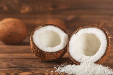 Tahta arka planda taze hindistan cevizi ve dilimler var. Hindistan cevizi gevreği. Vejetaryen. Tropik fındık, meyve. Mesaj için yer. Boşluğu kopyala.