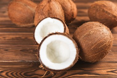 Tahta arka planda taze hindistan cevizi ve dilimler var. Hindistan cevizi gevreği. Vejetaryen. Tropik fındık, meyve. Mesaj için yer. Boşluğu kopyala.