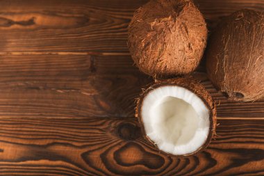 Tahta arka planda taze hindistan cevizi ve dilimler var. Hindistan cevizi gevreği. Vejetaryen. Tropik fındık, meyve. Mesaj için yer. Boşluğu kopyala.