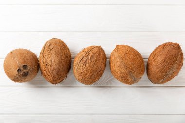 Tahta arka planda taze hindistan cevizi ve dilimler var. Hindistan cevizi gevreği. Vejetaryen. Tropik fındık, meyve. Mesaj için yer. Boşluğu kopyala.