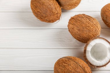 Tahta arka planda taze hindistan cevizi ve dilimler var. Hindistan cevizi gevreği. Vejetaryen. Tropik fındık, meyve. Mesaj için yer. Boşluğu kopyala.