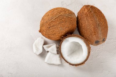 Tahta arka planda taze hindistan cevizi ve dilimler var. Hindistan cevizi gevreği. Vejetaryen. Tropik fındık, meyve. Mesaj için yer. Boşluğu kopyala.