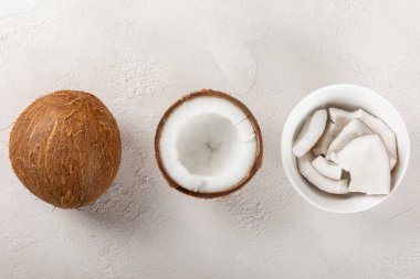 Tahta arka planda taze hindistan cevizi ve dilimler var. Hindistan cevizi gevreği. Vejetaryen. Tropik fındık, meyve. Mesaj için yer. Boşluğu kopyala.