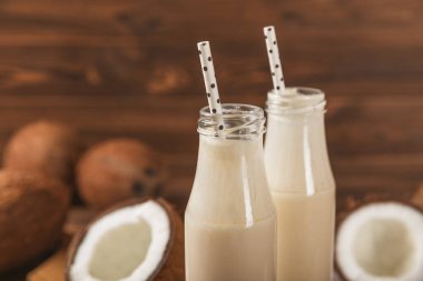 Bir şişe lezzetli hindistan cevizi sütü dokulu arka planda. Hindistan cevizli yoğurt ve hindistan cevizi. Vejetaryen çevre dostu ürün. Metin için boşluk. Boşluğu kopyala.