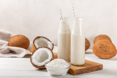 Tahta arka planda taze hindistan cevizi ve dilimler var. Hindistan cevizi gevreği. Vejetaryen. Tropik fındık, meyve. Mesaj için yer. Boşluğu kopyala.