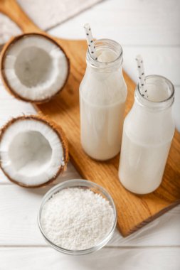 Tahta arka planda taze hindistan cevizi ve dilimler var. Hindistan cevizi gevreği. Vejetaryen. Tropik fındık, meyve. Mesaj için yer. Boşluğu kopyala.