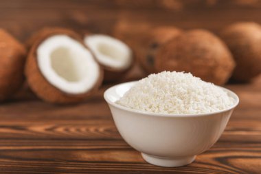 Tahta arka planda taze hindistan cevizi ve dilimler var. Hindistan cevizi gevreği. Vejetaryen. Tropik fındık, meyve. Mesaj için yer. Boşluğu kopyala.