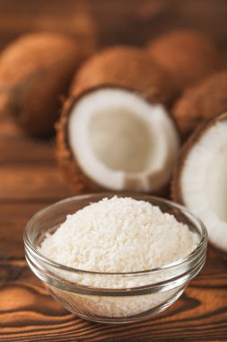 Tahta arka planda taze hindistan cevizi ve dilimler var. Hindistan cevizi gevreği. Vejetaryen. Tropik fındık, meyve. Mesaj için yer. Boşluğu kopyala.